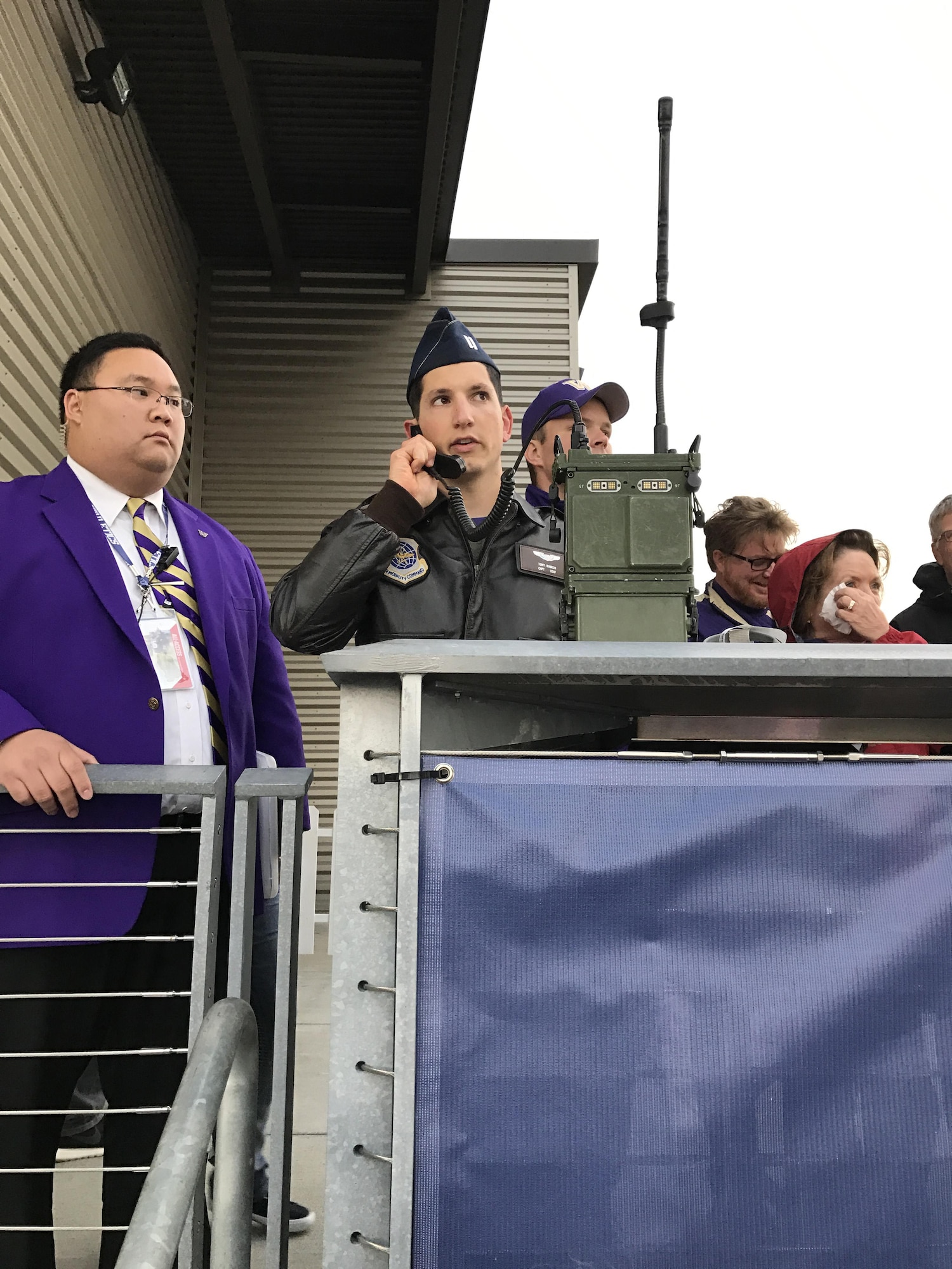 Capt. Anthony Bianchi, 62nd Operations Support Squadron executive officer, and Josh T. Chan, Husky Athletic Bands and Spirits Squads program coordinator, work to get the C-17 Globemaster III flyover timed perfectly for the University of Washington pre-game Veterans Day salute Nov. 12. (U.S. Air Force photo by Jason Waggoner)