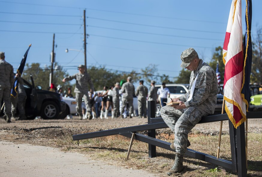 An Airman reads prior to the start of the Veterans Parade at the State Fair of Louisiana in Shreveport, Nov. 13, 2016. As part of the parade, 50 Airmen marched down the route, each holding a state flag. (U.S. Air Force photo/Senior Airman Damon Kasberg)