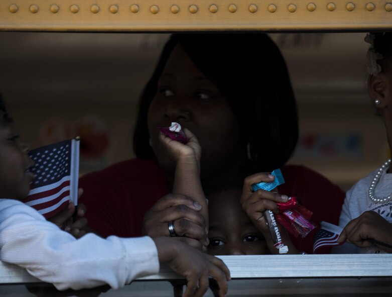 A child tosses candy from a bus during the Veterans Parade at the State Fair of Louisiana in Shreveport, Nov. 13, 2016. People of all ages participated and attended the parade to honor veterans. (U.S. Air Force photo/Senior Airman Damon Kasberg)