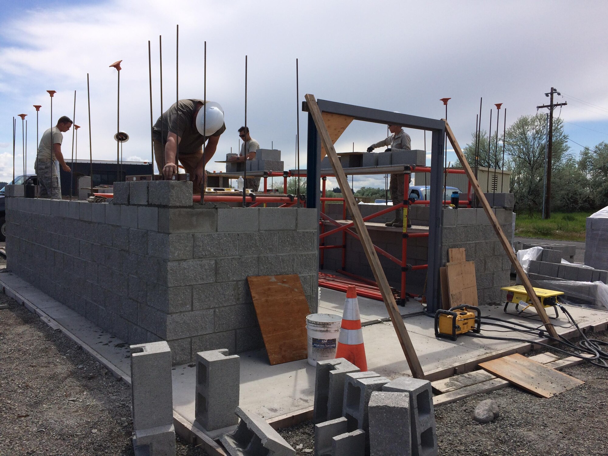Members from the 92nd Civil Engineer Squadron lay bricks for the frame of the pump house May 16, 2016, at Fairchild Air Force Base, Wash. Both military and civilian members from eight career fields worked on building the new pump house, from designing the layout to pouring the concrete foundation and even rerouting electrical lines from the old facility. (Courtesy photo)