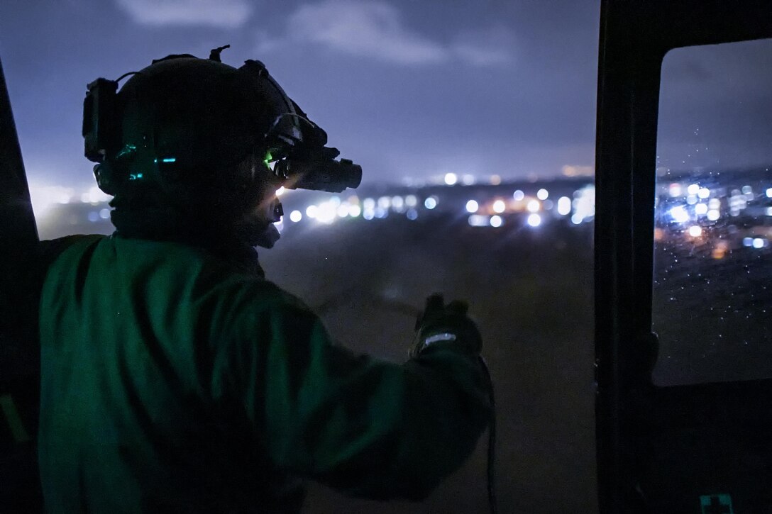 Japan Air Self-Defense Force Tech. Sgt. Yuji Yasutani, Komatsu Air Rescue Squadron UH-60J flight engineer, performs visual conformation with vision goggles over Combined Arms Training Center Camp Fuji, Japan, Nov. 8, 2016, during the Keen Sword 17. The 459th AS and Komatsu Air RQS Airmen conducted a three-day NVGs and hoist familiarization training. (U.S. Air Force photo by Yasuo Osakabe/Released)  