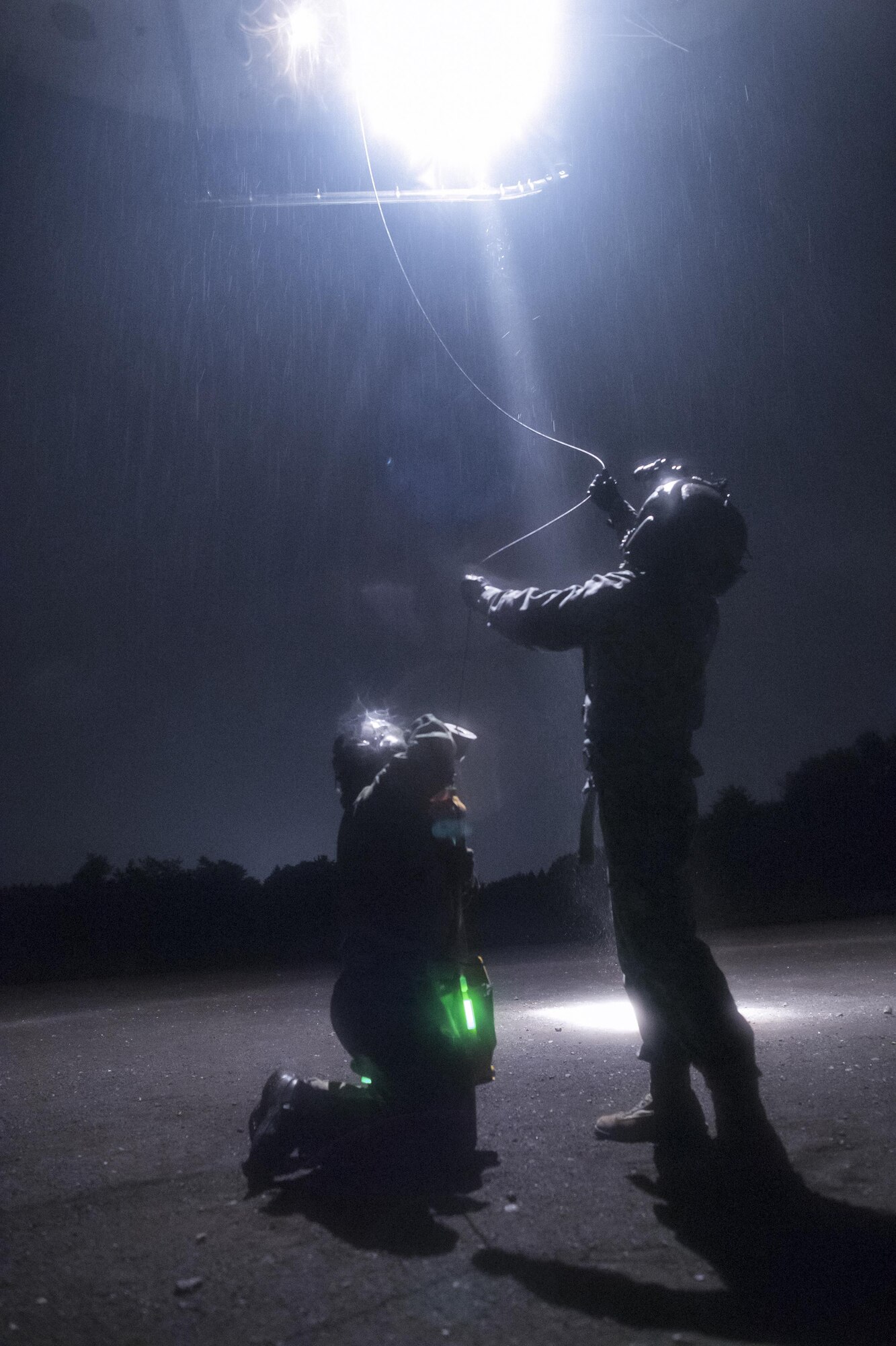 (Right to left) Japan Air Self-Defense Force Tech Sgt. Shohei Sakane, Komatsu Air Rescue Squadron pararescue jumper, and JASDF Tech. Sgt. Yuji Yasutani, Komatsu ARQS UH-60J flight engineer, get hoisted to an U.S. Air Force UH-1N Iroquois at Combined Arms Training Center Camp Fuji, Nov. 8, 2016, during the Keen Sword 17. The 459th AS and Komatsu Air RQS Airmen conducted a three-day NVGs and hoist familiarization training. (U.S. Air Force photo by Yasuo Osakabe/Released)  