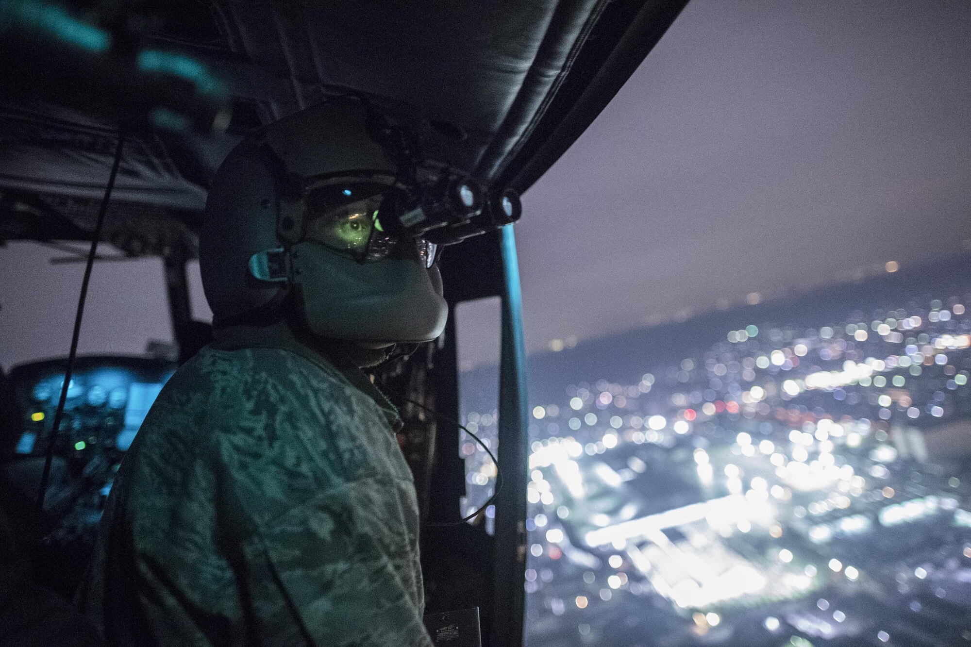 Staff Sgt. Nicholas Poe, 459th Airlift Squadron UH-1N flight engineer, performs a visual conformation with night vision goggles during the Keen Sword 17 over Yokota Air Base, Japan, Nov. 8, 2016, during the Keen Sword 17. The 459th AS and Komatsu Air RQS Airmen conducted a three-day NVGs and hoist familiarization training. (U.S. Air Force photo by Yasuo Osakabe/Released)  