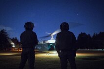 (Right to left) Japan Air Self-Defense Force Maj. Hirotaka Nakamura and Maj. Junichi Okamoto, Komatsu Air Rescue Squadron UH-60J pilots, wait for a U.S. Air Force UH-1N Iroquois takeoff at U.S. Army Sagami General Depot, Nov. 9, 2016, during the Keen Sword 17. The 459th AS and Komatsu Air RQS Airmen conducted a three-day NVGs and hoist familiarization training. (U.S. Air Force photo by Yasuo Osakabe/Released)  