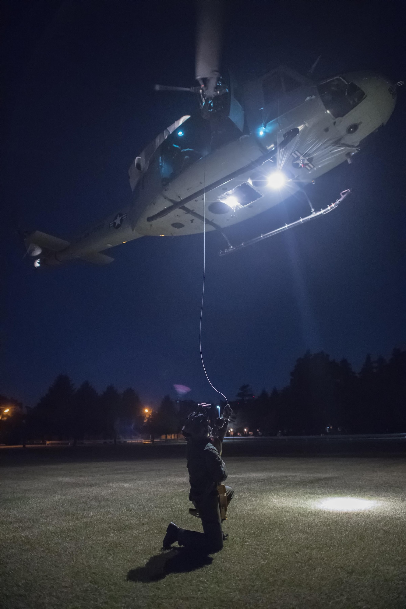 Japan Air Self-Defense Force Maj. Junichi Okamoto, Komatsu Air Rescue Squadron UH-60J pilot, get hoisted to an U.S. Air Force UH-1N Iroquois at U.S. Army Sagami General Depot, Nov. 9, 2016, during the Keen Sword 17. The 459th AS and Komatsu Air RQS Airmen conducted a three-day NVGs and hoist familiarization training. (U.S. Air Force photo by Yasuo Osakabe/Released)  