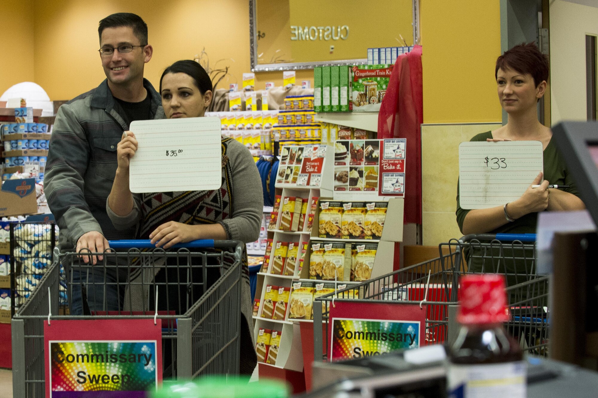 U.S Air Force Tech. Sgt. Josh Pectol, left, 52nd Maintenance Squadron munitions inspection production supervisor, Jamie Pectol, left center, 52nd Medical Group nurse specialist, and Erica Sansoti, right, 52nd Medical Group patient evaluation board liaison officer, guess prices on food items as contestants during the Spangdahlem Spouses and Enlisted Members Club Commissary Sweep at Spangdahlem Air Base, Germany, Nov. 15, 2016. The event gave participants the opportunity to receive free groceries and Commissary gift cards ranging from $50 to $200. (U.S. Air Force photo by Airman 1st Class Preston Cherry)