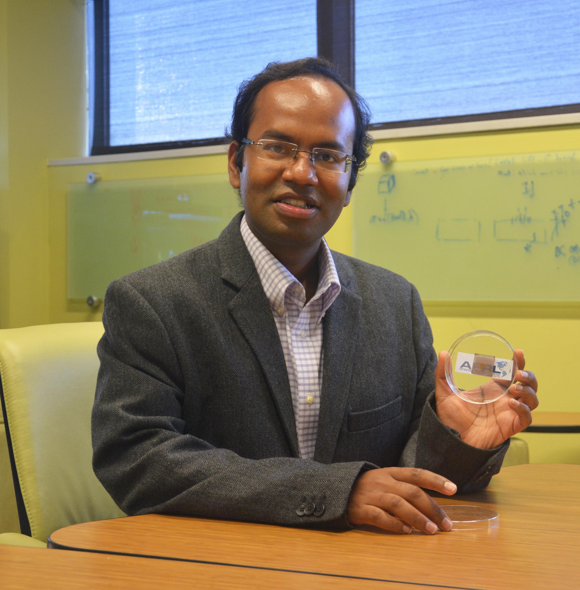 Dr. Santanu Bag holds a thin-film perovskite solar cell developed by the AFRL research team.  These transparent and more-efficient solar cells could play an integral role next-generation Air Force power applications. (U.S. Air Force Photo/David Dixon)