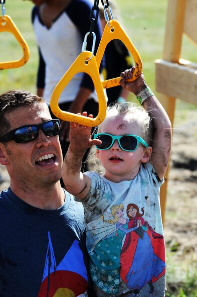 A military child goes through an obstacle during the 2016 Mini Mudder, July 15, 2016 at Minot Air Force Base, N.D. The race consisted of different obstacles that challenged Airmen and their families to crawl, climb, run and slide through mud and water. (U.S. Air Force photo/Senior Airman Kristoffer Kaubisch)