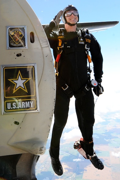 A member of the U.S. Golden Knights Army Parachute Team salutes as he jumps out of a plane at the Northern Neighbors Day 2016 Air Show at Minot Air Force Base, N.D., Aug. 13, 2016. The team performs parachute demonstrations at air show, major league football and baseball games, and other special events, connecting the Army with the American people. (U.S. Air Force photo/Senior Airman Kristoffer Kaubisch)