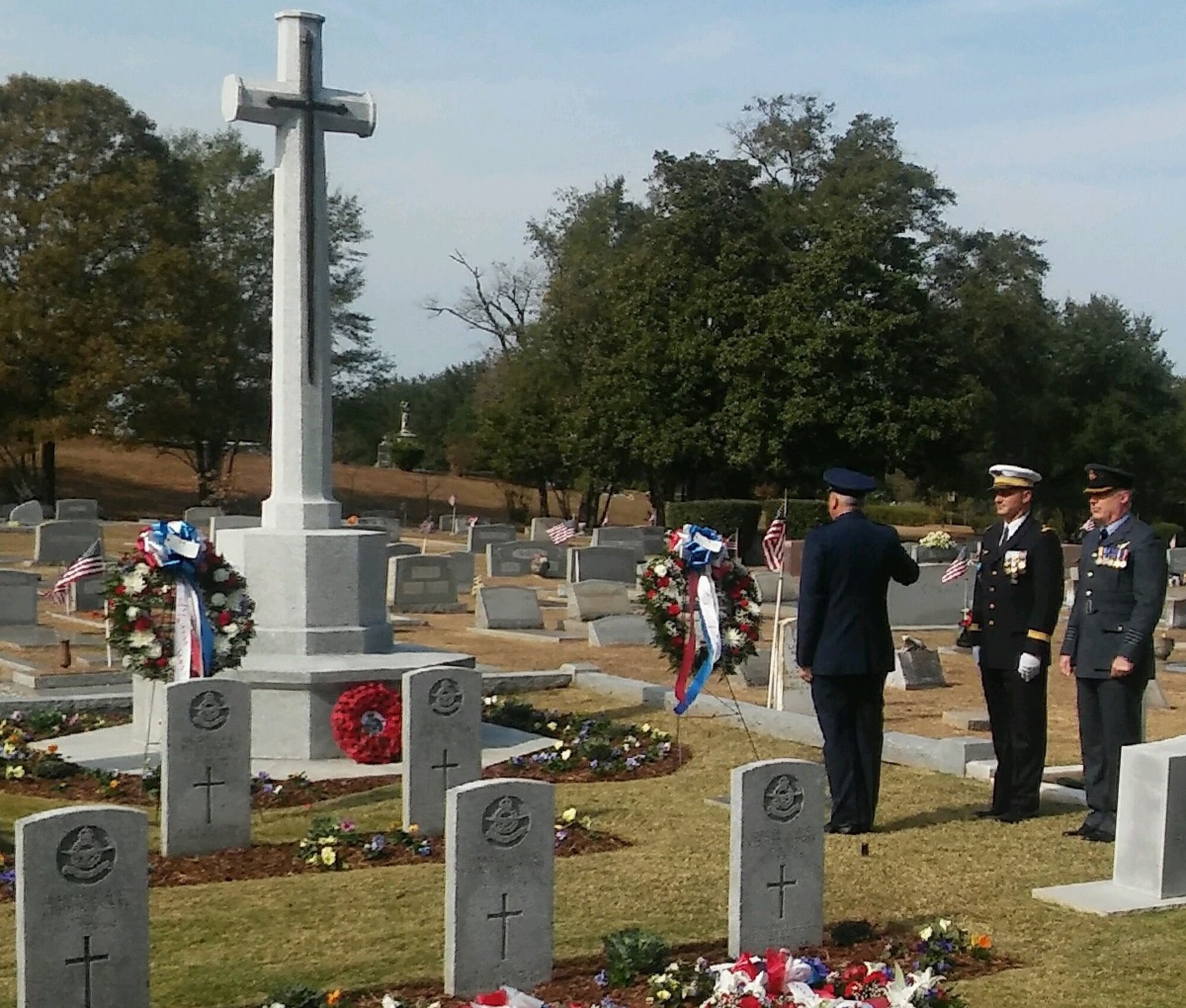 Brig. Gen. Christopher A. Coffelt, commandant, Air War College, salutes facing the Cross of Sacrifice with French Air Force Lieutenant Colonel Fabrice Imbo and RAF Group Captain Paul Taylor Nov. 13, 2016, at Oakwood Cemetery, Montgomery Alabama.  In the cemetery are buried 78 British and 20 French Airmen killed in training accidents in the Southeast U.S. from June 1941 to November 1945. (Photo courtesy of Dr. Robert Kane, Air University Director of History)