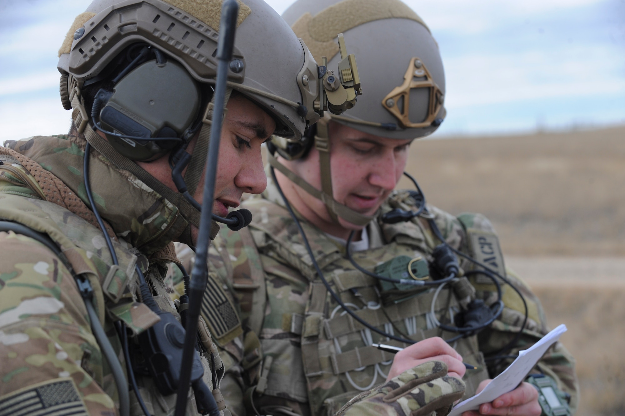 Staff Sgts. Edward Breen and Michael Pincher, joint terminal attack controllers assigned to the 5th Air Support Operations Squadron, Joint Base Lewis-McChord, Wash., write down location coordinates during a joint training exercise at the Powder River Training Complex, Belle Fourche, S.D., Nov. 16, 2016. The training exercise was designed to train both JTACs and aircrew under realistic scenarios that support full spectrum operations against modern threats. (U.S. Air Force photo by Senior Airman Anania Tekurio/Released)