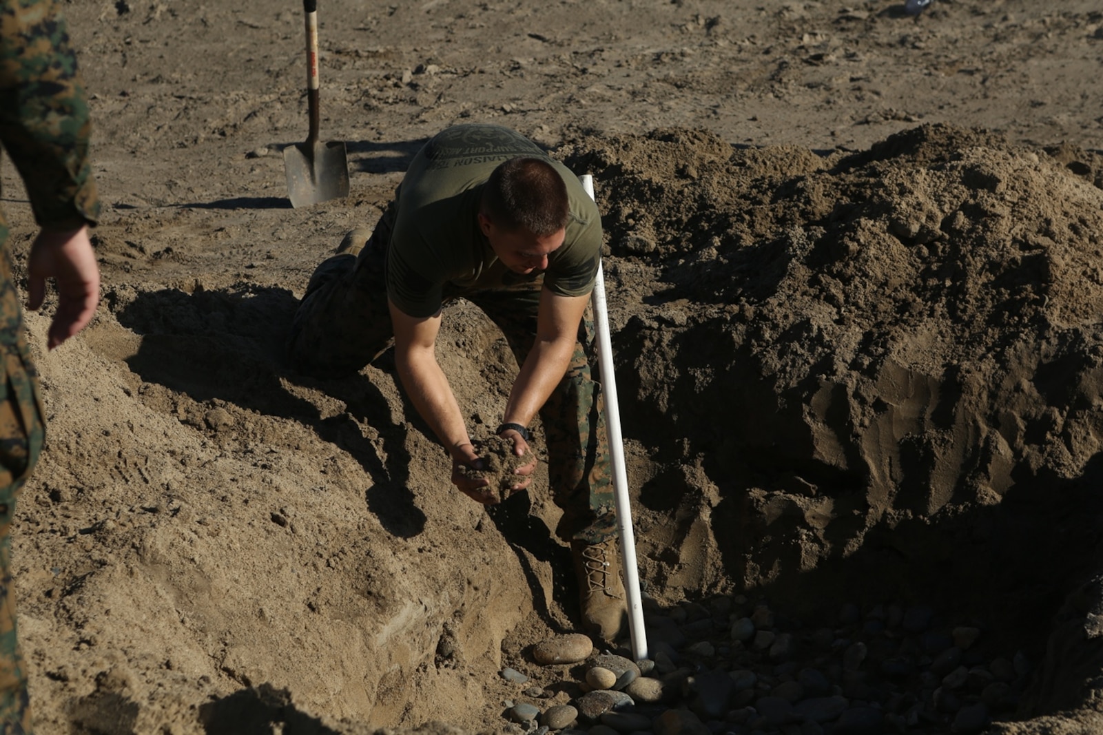 U.S. Navy Petty Officer 2nd Class Michael Mathews helps to set up a grey water sanitation soakage pit during Preventative Medicine Exercise 2016 at Camp Pendleton, Calif., Nov. 10, 2016. The pit is 5 feet long, 5 feet wide, and 5 feet deep filled with small rocks and pipes to safely transfer waste to the ground. Grey water is any substance that could potentially be harmful to the environment and special precautions are made to keep the exercise’s area safe. Matthews is a preventive medical technician with 1st Medical Battalion, 1st Marine Logistics Group. (U.S. Marine Corps photo by Lance Cpl. Joseph Sorci)