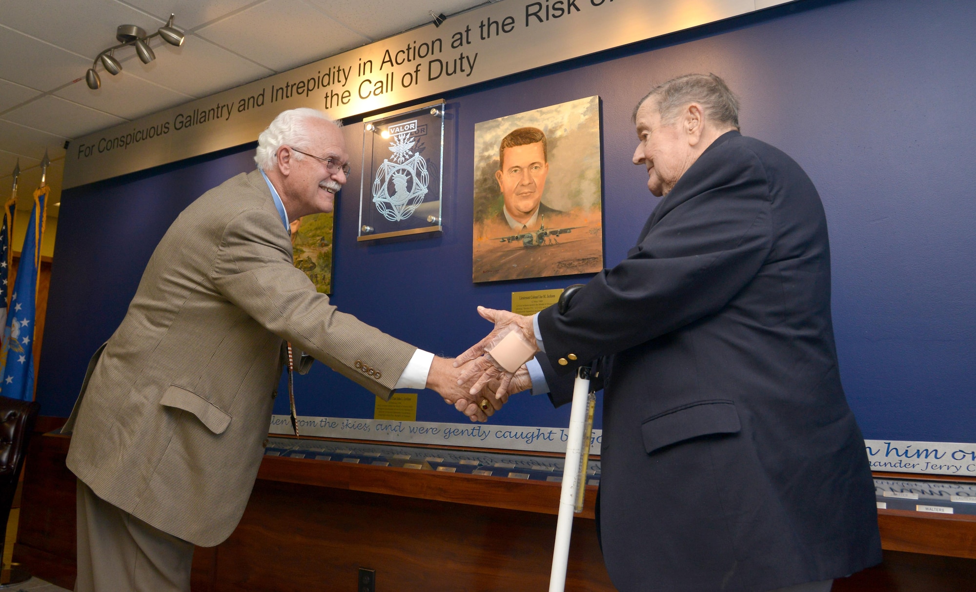 Air Force Medal of Honor recipients and retired Cols. James Fleming, left, and Joe Jackson shake hands after unveiling the 58th Special Operations Wing Medal of Honor memorial wall during a ceremony Nov. 15. 