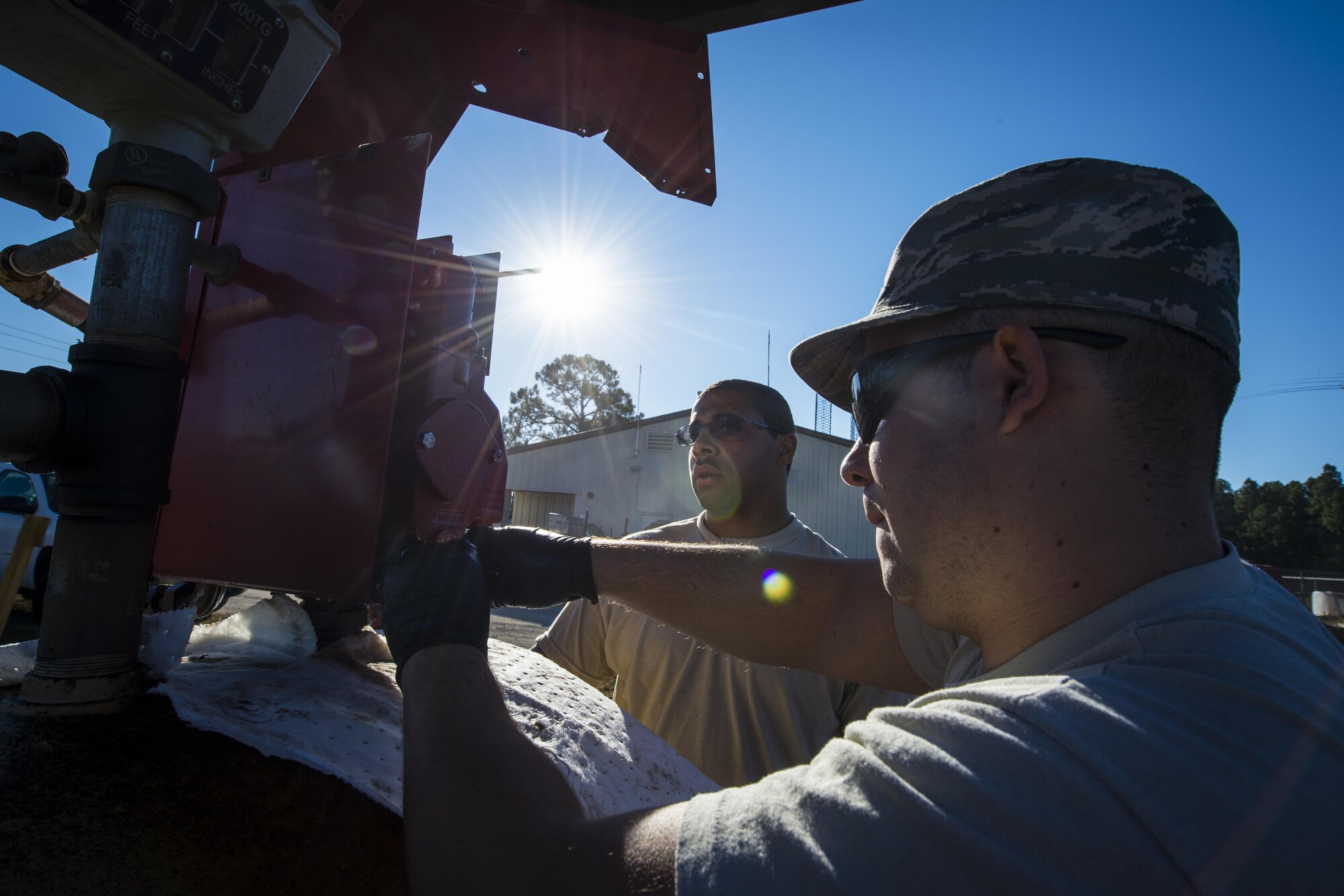 Senior Airmen Chris Coney, left, and Dacota Napolitano, water and fuels system specialists with the 1st Special Operations Civil Engineer Squadron, remove a fuel pump from a fuel tank at Hurlburt Field, Fla., Nov. 17, 2016. The 1st SOCES replaced the fuel pump with a new one. (U.S. Air Force photo by Airman 1st Class Joseph Pick)