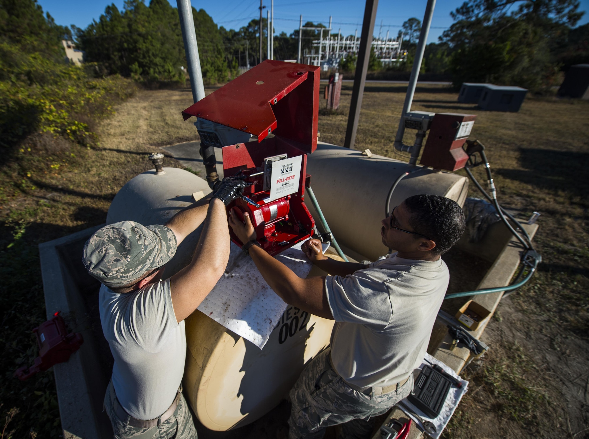 Senior Airmen Dacota Napolitano, left, and Chris Coney, water and fuels system specialists with the 1st Special Operations Civil Engineer Squadron, remove a fuel pump from a fuel tank at Hurlburt Field, Fla., Nov. 17, 2016. The fuel tanks are used to hold fuel for lawn maintenance equipment that maintain Hurlburt’s Gator Lakes Golf Course. (U.S. Air Force photo by Airman 1st Class Joseph Pick)