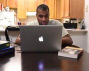 Tech. Sgt. Christopher McShan II, 341st Civil Engineer Squadron emergency management flight section chief, works on his computer at his home at Malmstrom Air Force Base, Mont., Nov. 17, 2016. McShan recently received his conferral date for his college graduation Nov. 15, and is expected to graduate May 2018. (U.S. Air Force photo/Senior Airman Jaeda Tookes)
