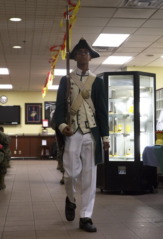 A cadet with the Kubasaki High School Marine Corps Junior Reserve Officer Training Corps marches in the uniform of the continental Marines in the Revolutionary War during the 241st Marine Corps Birthday celebration at the Marine Corps Air Station Futenma mess hall Nov. 9 on MCAS Futenma, Okinawa, Japan. The uniform pageant detailed and displayed the history behind Marine Corps uniforms from its foundation in 1775 until the present day. In addition to the pageant and a special meal of steak and lobster, patrons enjoyed live music by the III Marine Expeditionary Force Band. (U.S. Marine Corps photo by Cpl. Janessa K. Pon/Released)