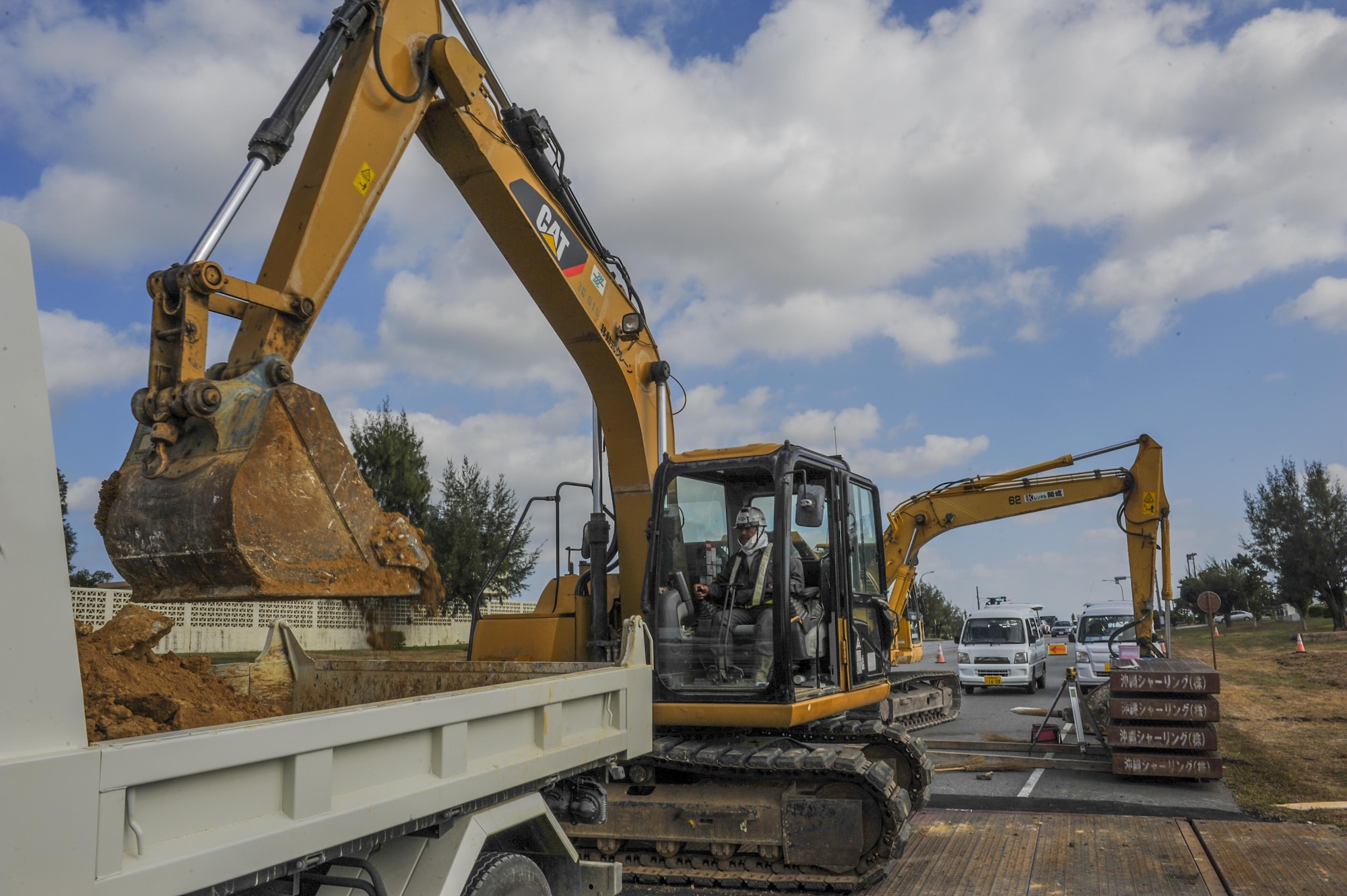 Mineyuki Ikei, an excavator operator with Kochi Construction, operates an excavator while assisting in the replacement of sewer pipes Nov. 16, 2016, at Kadena Air Base, Japan. Due to heavy rainfall in Okinawa, storm drains and pipelines require routine maintenance. (U.S. Air Force photo by Airman 1st Class Nick Emerick/Released) 