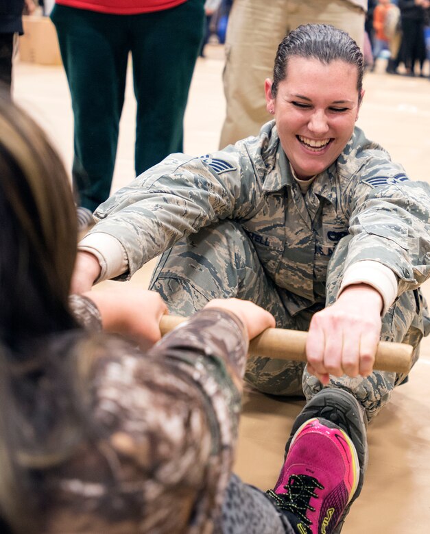 TOGIAK, Alaska -- Staff Sgt. Katelyn Martell, with the Air Force Reserve's 55th Aerial Port Squadron, competes in an Eskimo stick contest with a schoolgirl here Nov. 15, 2016. Martell was one of a handful of reservists who traveled here from Travis Air Force Base, Calif., to assist the Alaska National Guard with Operation Santa Claus 2016. Now in its 60th year, Operation Santa Claus is an Alaska National Guard-led program that delivers toys, school supplies and other gifts to children in Alaska's remote villages. National Guard photo by Maj. John Callahan.