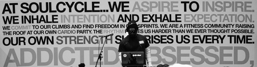 A disc jockey plays music during a United Service Organizations-hosted cycling class, SoulCycle, at Ramstein Air Base, Germany, Nov. 15, 2016. SoulCycle, an American fitness company, offers mood lighting, a cadre of support staff to help its participants throughout the class, and musical beats to choreograph cycling moves. (U.S. Air Force photo by Airman 1st Class Lane T. Plummer)