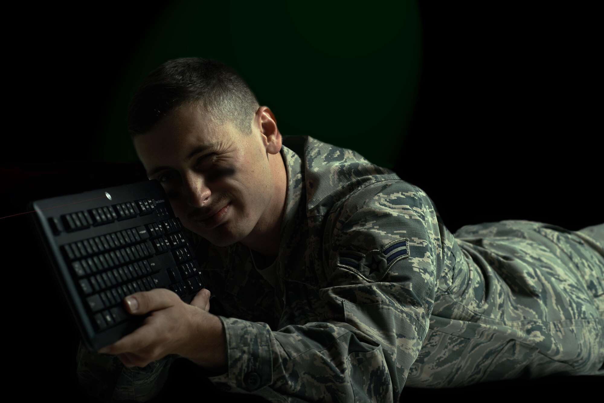 U.S. Air Force Airman 1st Class Jared Traughber, a client support administrator with the 379th Expeditionary Operations Support Squadron, poses for a photo at Al Udeid Air Base, Qatar, Nov. 15, 2016. Client support administrators at Al Udeid AB ensure the operability of communication channels, organizationally shared emails, shared drives and email-distribution lists. (U.S. Air Force photo illustration by Senior Airman Cynthia A. Innocenti)