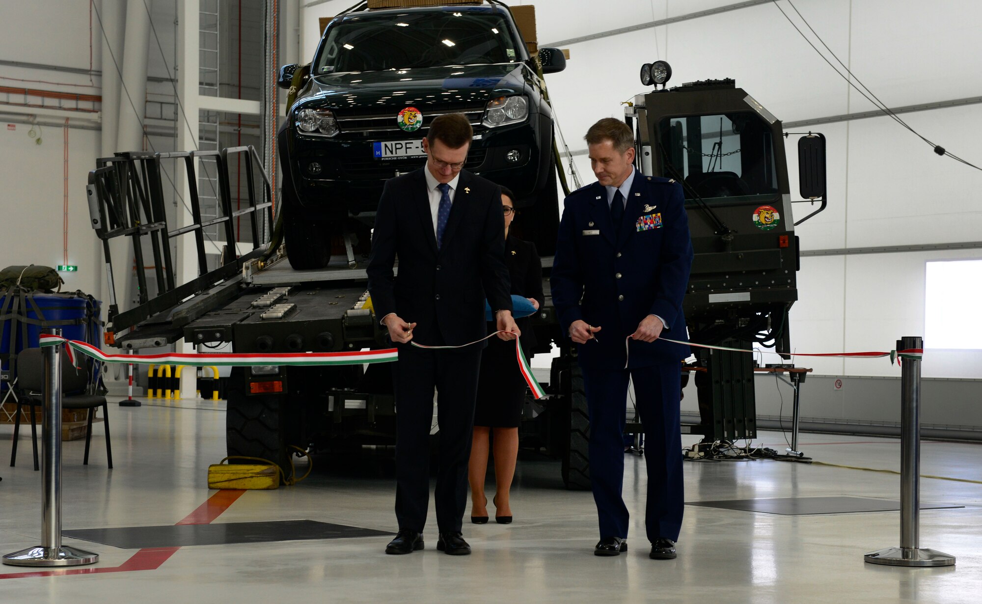 Wiek Noldus, NATO Support Agency Airlift Management program manager, and U.S. Air Force Col. Trevor Nitz, Heavy Airlift Wing commander, cut a ribbon signifying the grand opening of a new C-17 Globemaster III hangar complex at Pàpa Air Base, Hungary on Nov. 17, 2016. The hangar complex will allow the HAW to perform maintenance on the Strategic Airlift Capability program’s three C-17s. (U.S. Air Force photo by Staff Sgt. Krystal Ardrey)