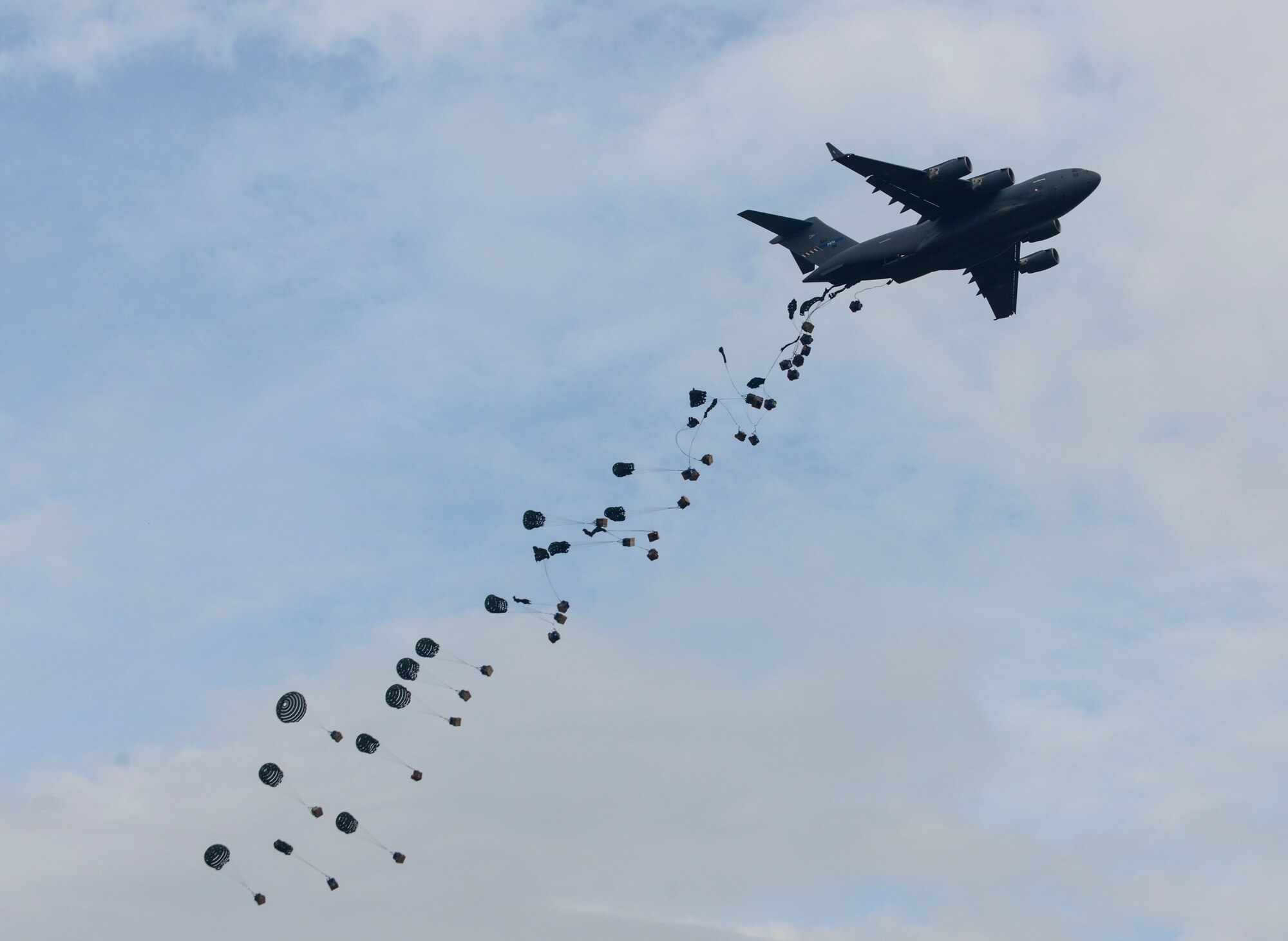 A C-17 Globemaster III drops 32 bundles of cargo during a demonstration at the C-17 hangar complex grand opening at Pàpa Air Base, Hungary on Nov. 17, 2016. The new hangar complex will allow the Heavy Airlift Wing to more efficiently maintain their C-17s. (U.S. Air Force photo by Staff Sgt. Krystal Ardrey)