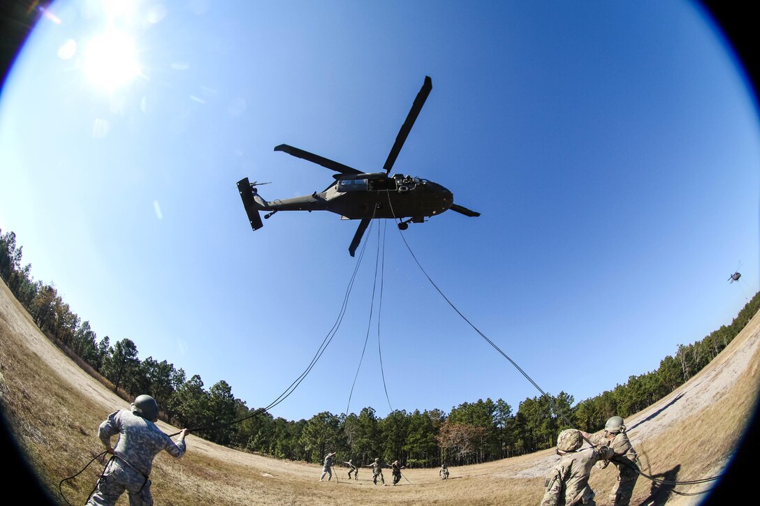 Soldiers extend ropes for classmates to rappel from a UH-60 Black Hawk helicopter at Fort Bragg, N.C., Nov. 17, 2016. The soldiers, assigned to the 18th Airborne Corps, are students attending the DeGlopper Air Assault School. The Black Hawk is assigned to the 82nd Airborne Division's 2nd Assault Helicopter Battalion, 82nd Combat Aviation Brigade. Army photo by Sgt. Steven Galimore