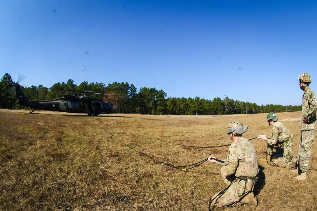 An instructor and two Army students from the  DeGlopper Air Assault School prepare for the liftoff of a UH-60 Black Hawk helicopter at Fort Bragg, N.C., Nov. 17, 2016.  Army photo by Sgt. Steven Galimore