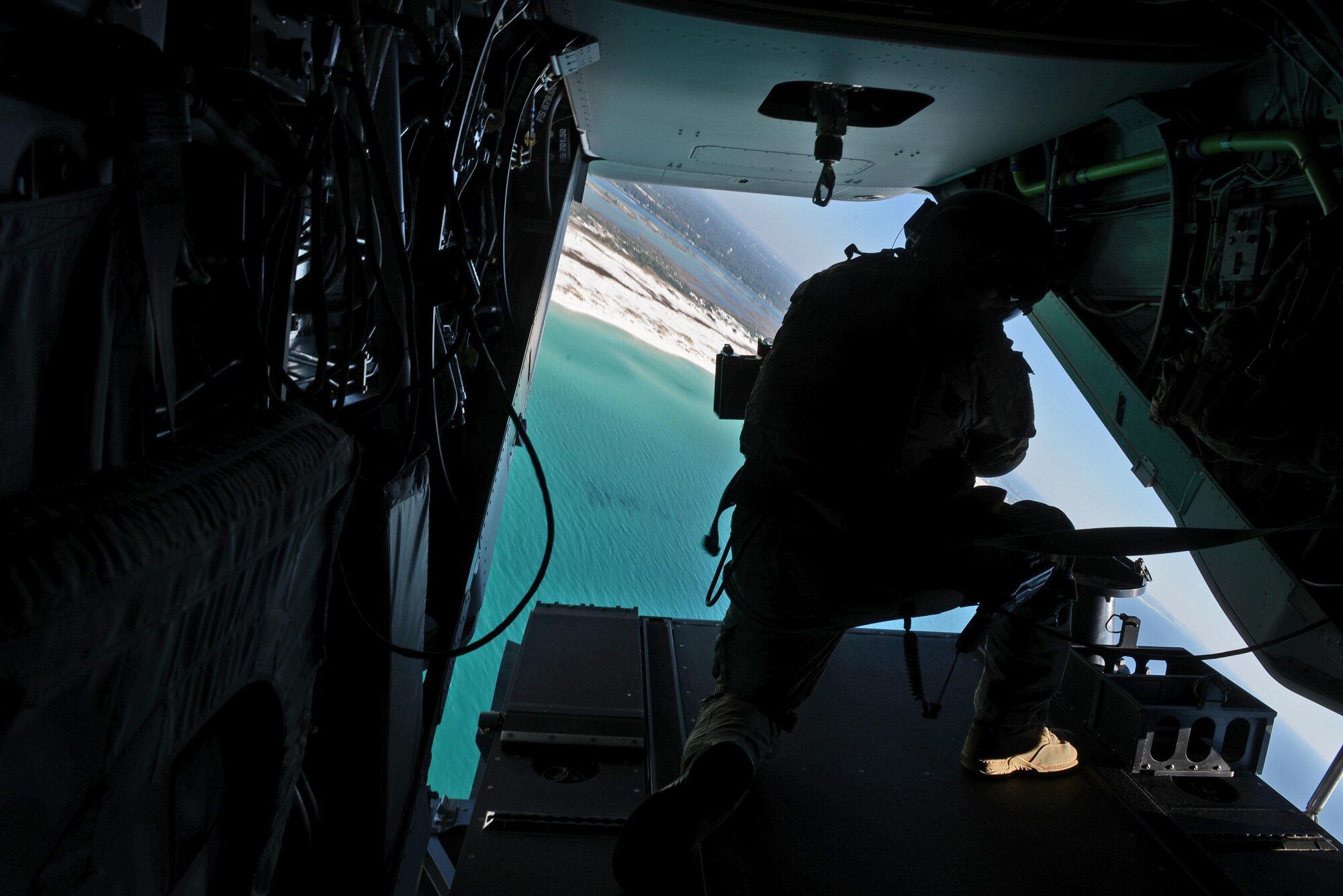 An aerial gunner with the 8th Special Operations Squadron mans the .50 caliber machine gun on a CV-22 Osprey Nov. 17, 2016 over Northwest Florida's gulf coast. Lt. Gen. Brad Webb, commander of Air Force Special Operations Command, escorted Secretary of Defense Ash Carter to the Eglin Range via CV-22 Osprey to observe a special tactics demonstration. (U.S. Air Force photo/Staff Sgt. Melanie Holochwost)