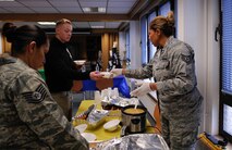 Tech Sgt. Thedna Yellow Bear Baskin (right), and Tech. Sgt. Tracy Valdez (left), 24th Intelligence Squadron imagery mission supervisors, hand out traditional Native American food at a food tasting at Ramstein Air Base, Germany, Nov. 17, 2016. The three sisters soup and wojapi, a traditional Lakota Sioux dessert, were among some of the dishes prepared for the tasting. (U.S. Air Force photo by Airman 1st Class Savannah L. Waters)