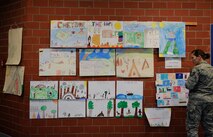 Tech. Sgt. Samantha Clark, Headquarters United States Air Forces in Europe command traffic manager, inspects posters for a Native American poster contest at Ramstein Elementary School at Ramstein Air Base, Germany, Nov. 18, 2016. Clark was one of four judges that came to the school to judge and choose a winning poster from each grade. (U.S. Air Force photo by Airman 1st Class Savannah L. Waters)

