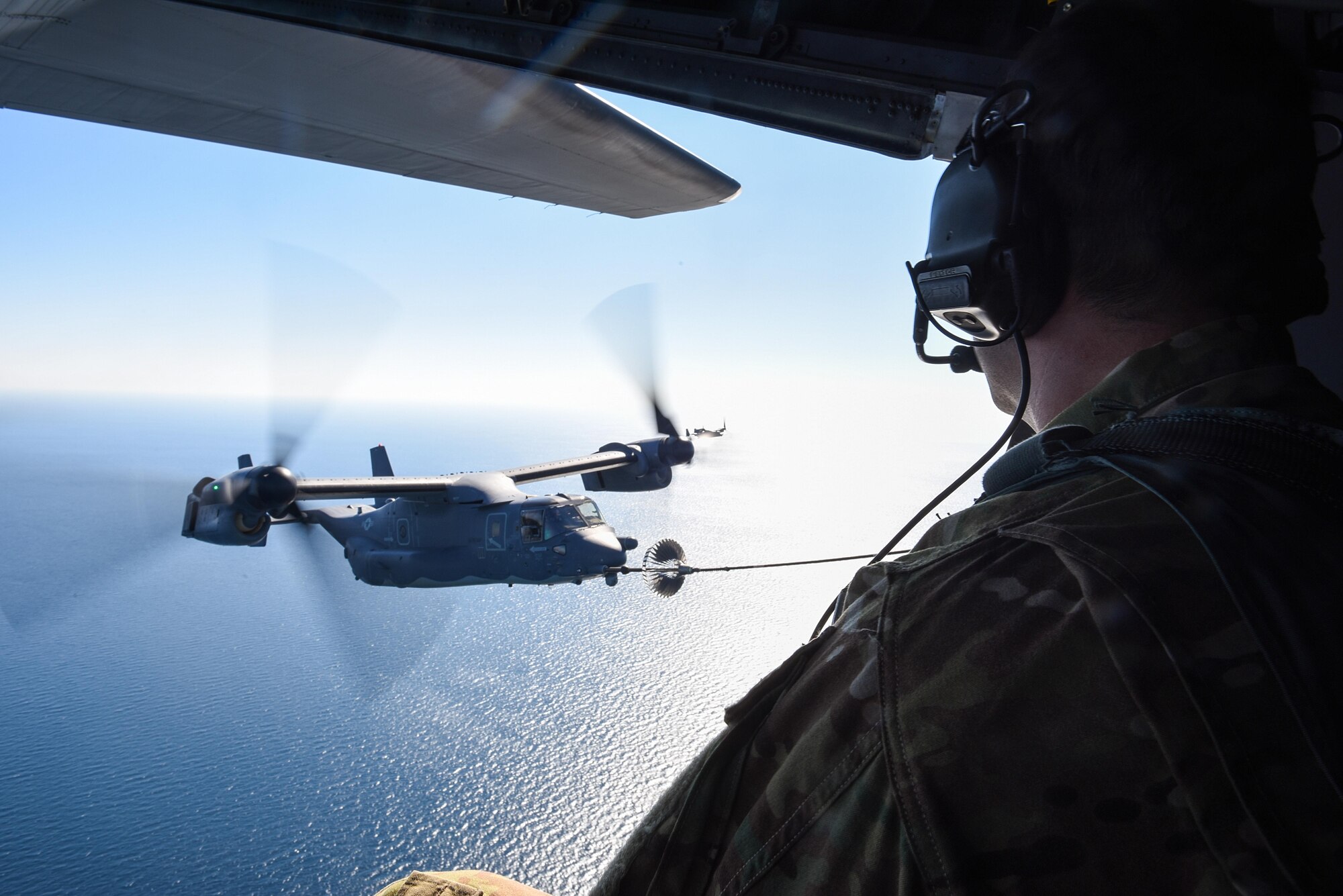 Tech. Sgt. Ian MacGregor, a loadmaster with the 15th Special Operations Squadron, observes a tiltrotor air-to-air refueling with a CV-22 Osprey assigned to the 8th SOS over the Gulf of Mexico, Nov. 17, 2016. Aircrews from the 8th and 15th SOS participated in a TAAR demonstration for Secretary of Defense Ash Carter during his visit to Hurlburt Field, Fla. (U.S. Air Force photo by Senior Airman Jeff Parkinson)