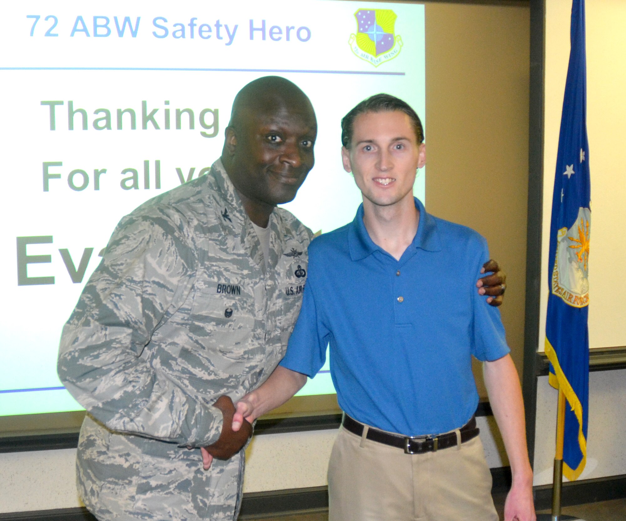 Col. Thomas Brown, 72nd Air Base Wing vice commander, congratulates Evan Blatt on being a safety hero. Mr. Blatt was recognized during a recent wing staff meeting for going the extra mile to keep others safe.  (Courtesy photo)