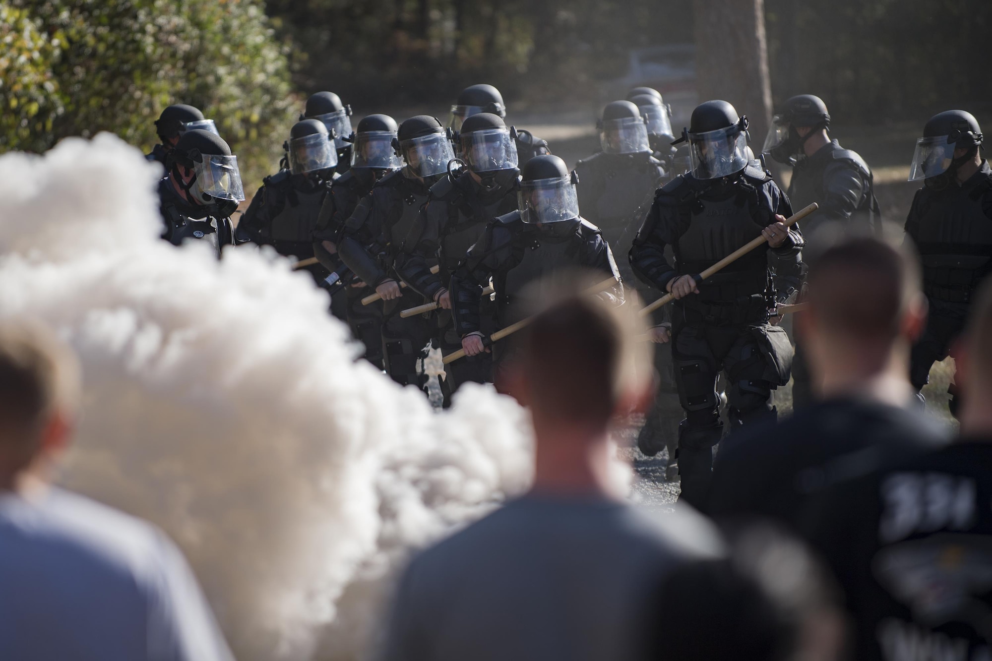 Members of Georgia State Patrol’s Mobile Field Force march toward a group of simulated rioters while a smoke grenade burns, Nov. 16, 2016, at Moody Air Force Base, Ga. Between the two days of training, approximately 45 GSP officers participated in the training. (U.S. Air Force photo by Airman 1st Class Daniel Snider)