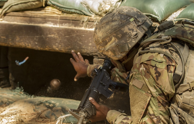 Pvt. Rolando Swaby, an Army Reserve Soldier in basic combat training with Company A, 1st Battalion, 61st Infantry Regiment at Fort Jackson, S.C., tosses a hand grenade into a bunker at the hand grenade assault course, Oct. 19. (U.S. Army Reserve photo by Sgt. Stephanie Hargett/ released)