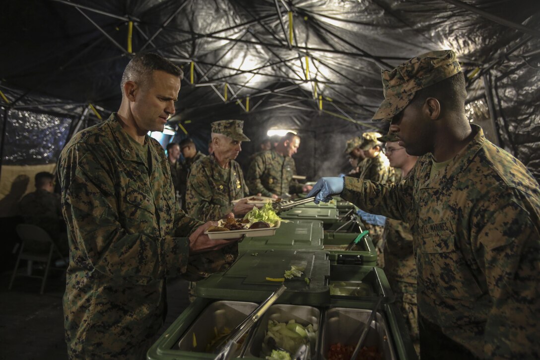 Corporal Logan Twitty serves Col. Andrew Niebel after the 2nd Marine Logistics Group squad competition at Camp Lejeune, N.C., Nov. 17, 2016. While the other Marines and Sailors take part in their competition, the food service Marines were critiqued on their ability to run an efficient and sanitary field mess hall for the annual W. P.T. Hill inspection. Twitty is with Food Service Company, Headquarters Regiment, 2nd MLG; Niebel is the commanding officer of Headquarters Regiment. (U.S. Marine Corps photos by Lance Cpl. Miranda Faughn)
