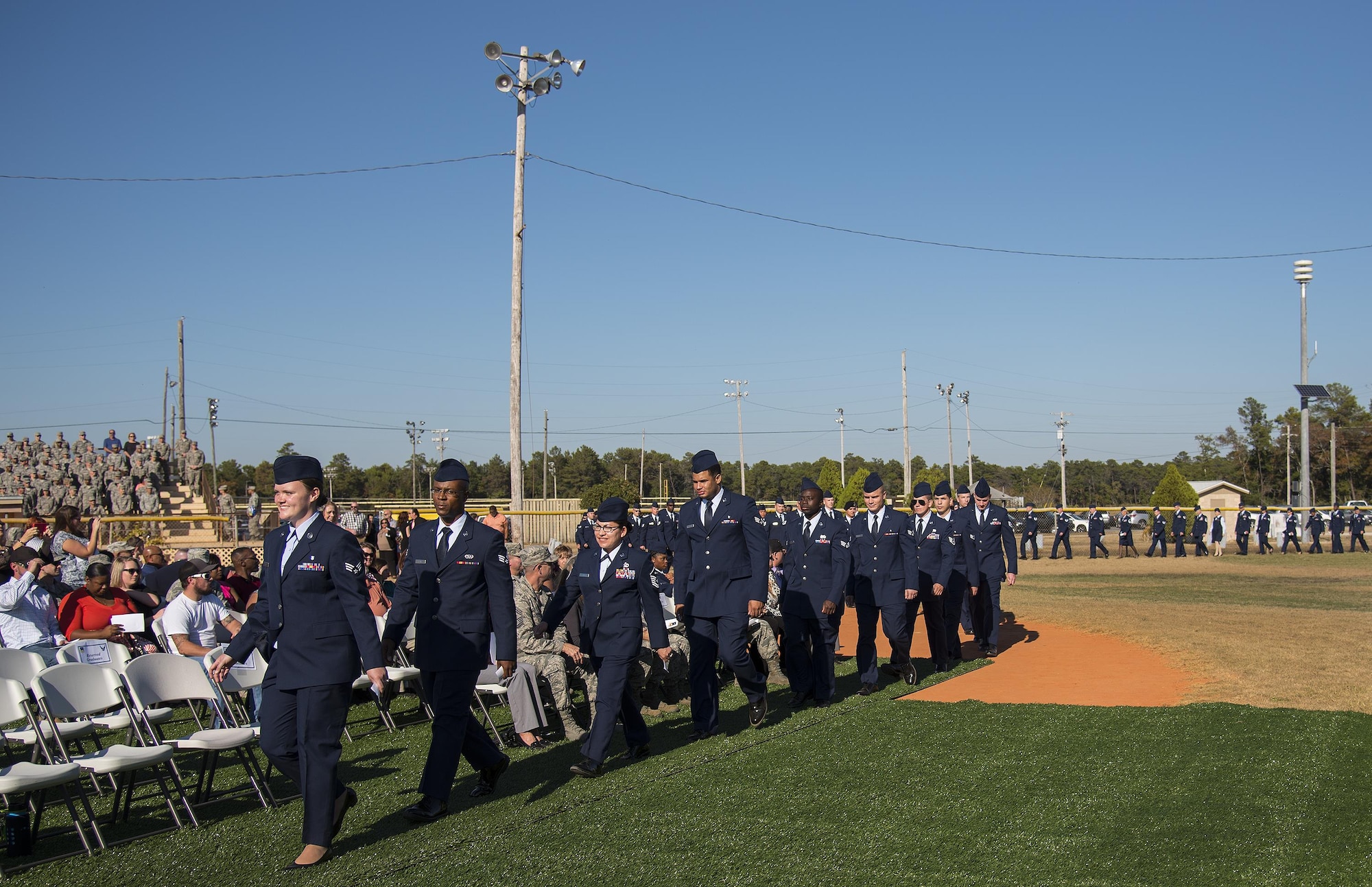A long line of Airmen in service dress march toward their seats during a Community College of the Air Force graduation ceremony at Eglin Air Force Base, Fla., Nov. 16.  More than 300 Airmen from Eglin and Duke Field were honored at this year’s event. (U.S. Air Force photo/Samuel King Jr.)