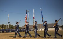 An Honor Guard team carries the colors by a line of Airmen waiting for their moment to enter the Community College of the Air Force graduation ceremony at Eglin Air Force Base, Fla., Nov. 16.  More than 300 Airmen from Eglin and Duke Field were honored at this year’s event. (U.S. Air Force photo/Samuel King Jr.)