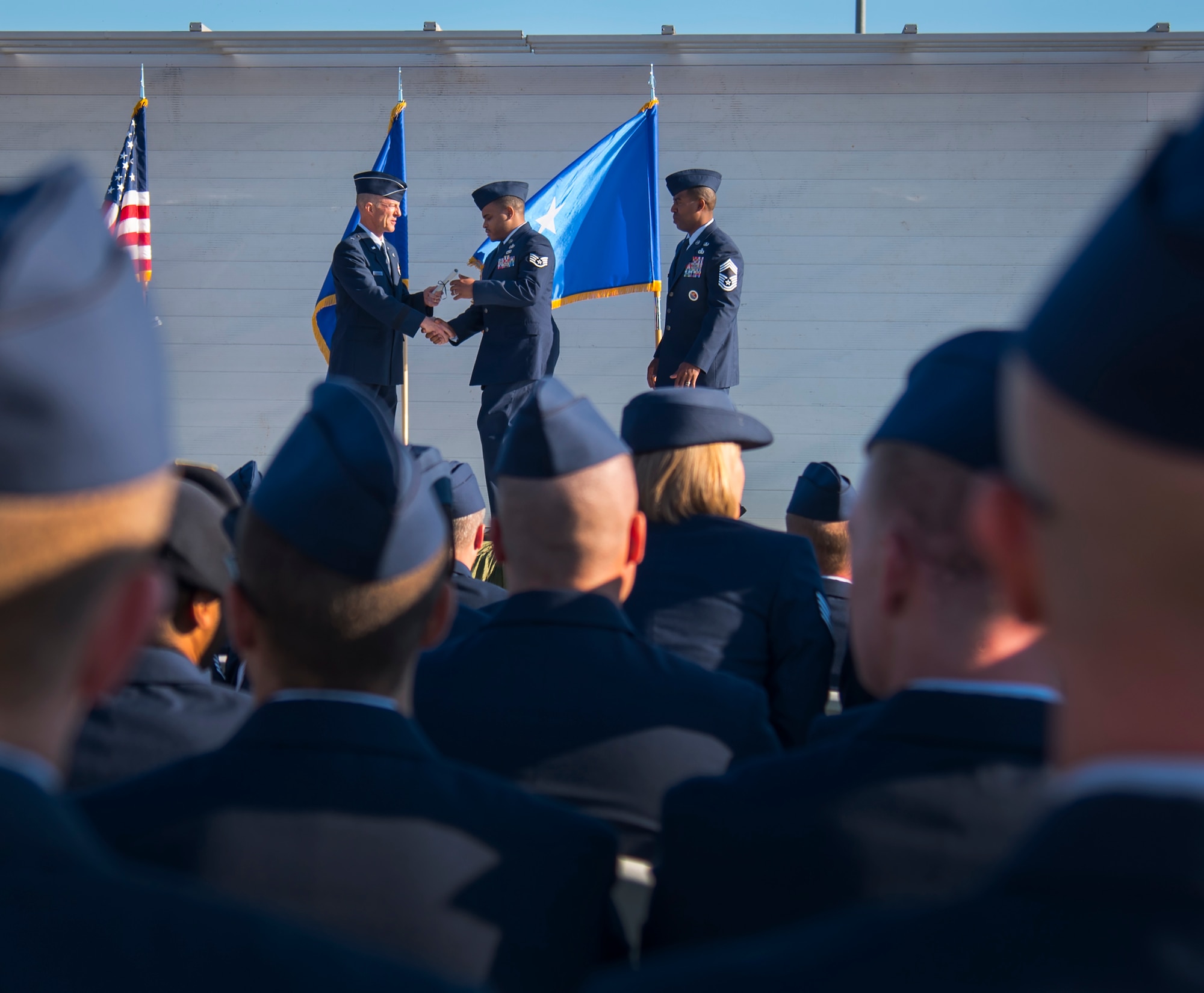 An Airman receives a certificate from Brig. Gen. Christopher Azzano, the 96th Test Wing commander, during a Community College of the Air Force graduation ceremony at Eglin Air Force Base, Fla., Nov. 16.  More than 300 Airmen from Eglin and Duke Field were honored at this year’s event. (U.S. Air Force photo/Samuel King Jr.)