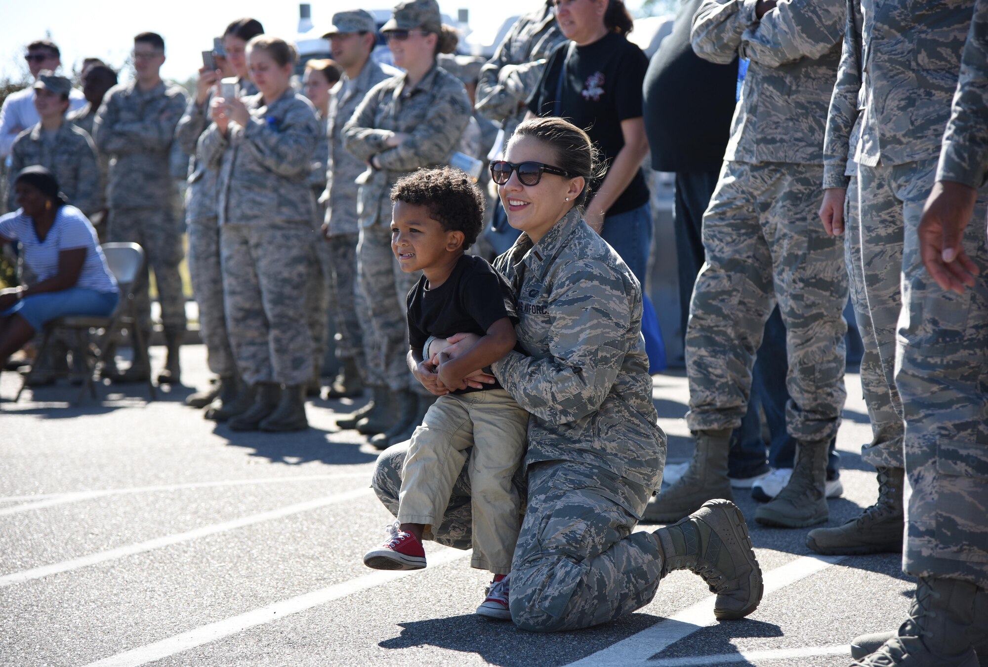 Second Lt. Jeagan Luna, 81st Comptroller Squadron financial services officer, holds Courtney Hill II, son of Staff Sgt. Courtney Hill, 81st Security Forces Squadron pass and ID NCO in charge, during a “Knock Out” drill competition at Dragon Fest Nov. 17, 2016, on Keesler Air Force Base, Miss. Dragon Fest was the final event held for Dragon Week, which focused on resiliency and teambuilding initiatives across the base. (U.S. Air Force photo by Kemberly Groue)