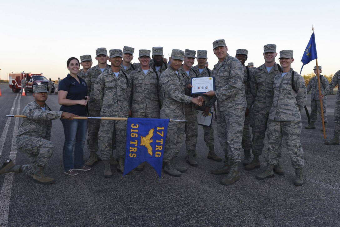 316th Training Squadron Airmen stand with their award as best drill team at the flight line on Goodfellow Air Force Base, Texas, Nov. 16, 2016. The 316th TRS drill team beat the 312th Training Squadron and 315th Training Squadron. (U.S. Air Force photo by Airman 1st Class Chase Sousa/Released)