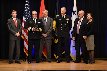 Capt. Michael Ladner, program manager Surface Ship Weapons holds his Program Manager of the Year award during the 2016 Department of the Navy Acquisition Excellence Awards ceremony at the Pentagon, Nov. 17.

Also pictured from left to right: Sean Stackley, Assistant Secretary of the Navy (Research, Development and Acquisition); William Bray, executive director, Program Executive Office Integrated Warfare Systems; Rear Adm. Doug Small, Program Executive Office Integrated Warfare Systems; Bill Deligne, executive director, Naval Sea Systems Command; Janine Anne Davidson, Under Secretary of the United States Navy.
