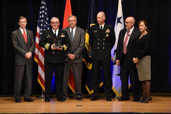 Capt. Michael Ladner, program manager Surface Ship Weapons holds his Program Manager of the Year award during the 2016 Department of the Navy Acquisition Excellence Awards ceremony at the Pentagon, Nov. 17.Also pictured from left to right: Sean Stackley, Assistant Secretary of the Navy (Research, Development and Acquisition); William Bray, executive director, Program Executive Office Integrated Warfare Systems; Rear Adm. Doug Small, Program Executive Office Integrated Warfare Systems; Bill Deligne, executive director, Naval Sea Systems Command; Janine Anne Davidson, Under Secretary of the United States Navy.