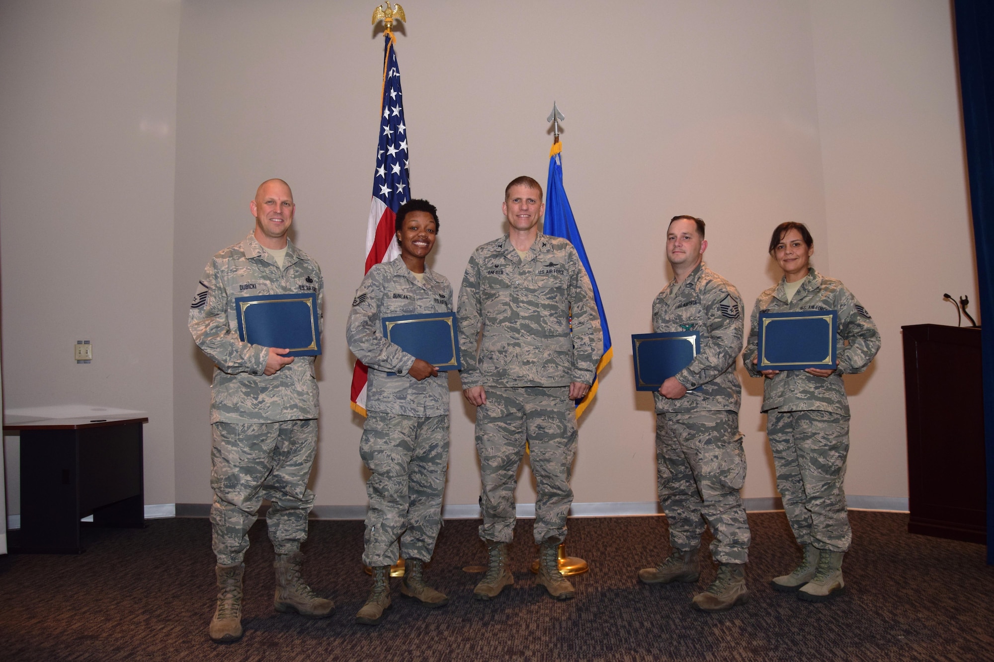 Col. David Enfield, center, 433rd Mission Support Group commander, congratulates, from left to right, Master Sgt. Jeremy Dubicki, Staff Sgt. Iliah Duncan, Master Sgt. Jonathan Boyd and Staff Sgt. Jennifer Martinez after they are presented their Community College of the Air Force degrees Nov. 5, 2016 in a ceremony held at the Inter American Air Forces Academy at Joint Base San Antonio-Lackland, Texas. (U.S. Air Force photo by Tech. Sgt. Carlos J. Treviño) 