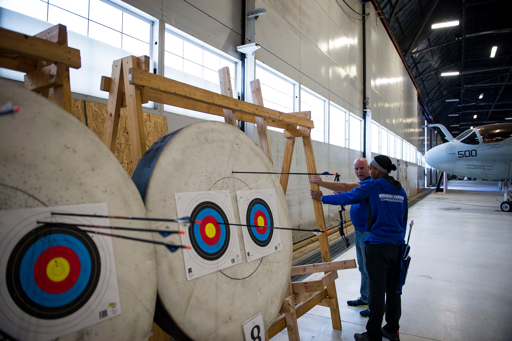 Jeff Matuszak, the Air Force Wounded Warrior Program archery head coach, gives pointers to Senior Airman Amanda Dotson, of the 779th Medical Support Squadron’s Airman Medical Transition Unit, during the Northeast Warrior CARE Event on Joint Base Andrews, Md., Nov. 18, 2016. The AFW2 regional CARE event provided a holistic opportunity for wounded warriors to enhance the four domains -- physical, mental, spiritual and social – of Comprehensive Airman Fitness. (U.S. Air Force photo/Staff Sgt. Christopher Gross)