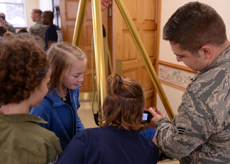 Zachary Miller, 97th Civil Engineer driver operator, shows students from local elementary schools a thermal imaging camera during the science, technology, engineering and math fair, Nov. 17, 2016, at Altus Air Force Base, Okla. The STEM fair brought together 5th grade students and teachers, showcasing STEM to local students and how those subjects can relate to different Air Force careers. (U.S. Air Force photo by Airman 1st Class Cody Dowell/Released)