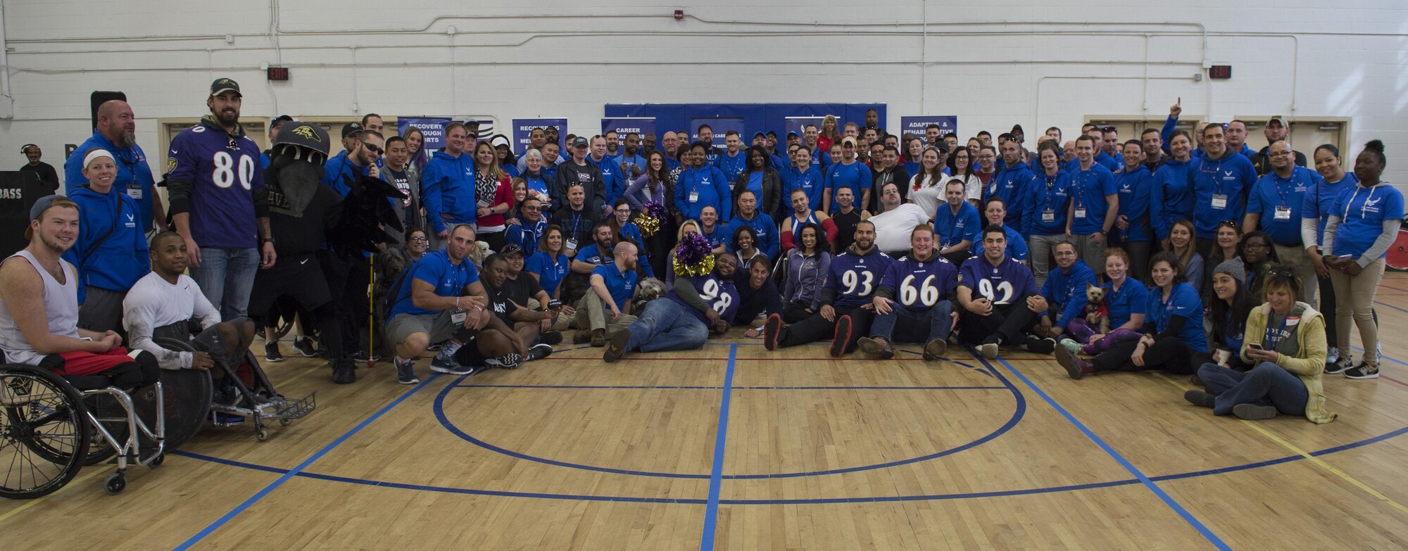Wounded Warriors, coaches and volunteers come together with Baltimore Ravens players, cheerleaders and mascot to take a group photo during the Northeast Region Warrior CARE Event at Joint Base Andrews, Md., Nov. 14, 2016. Ravens representatives made an appearance to show their support during the opening of the Warrior CARE week. The events are a part of a week-long program that features education in Caregiver Support, Adaptive and Rehabilitative Sports, Recovering Airman Mentorship, and Employment and Career Readiness. (U.S. Air Force photo by Senior Airman Philip Bryant)
