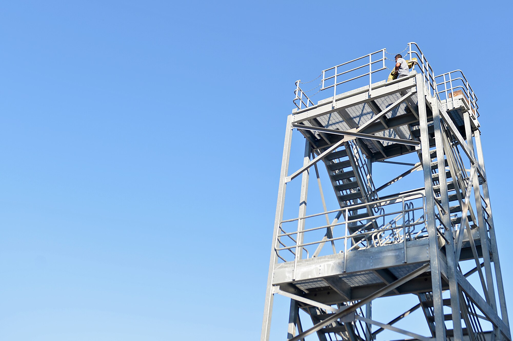 A U.S. Airman assigned to the 20th Aerospace Medicine Squadron carries a hose to the top of a tower during a Firefighter Combat Challenge 5K Run at Shaw Air Force Base, S.C., Nov. 18, 2016. Participants in the event overcame obstacles to include: mannequin transportation, operating fire hoses and tractor tire flips throughout the run. (U.S. Air Force photo by Airman 1st Class Christopher Maldonado)