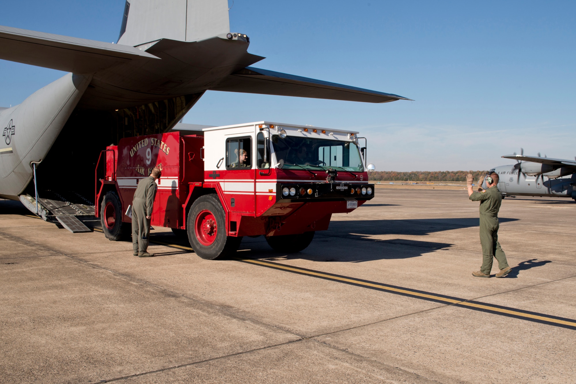U.S. Air Force Reserve Master Sgt. Scott Klobucher, loadmaster, 327th Airlift Squadron, directs the driver of a P-19 Fire Fighting Truck during the “Turkey Shoot” competition, Nov. 17, 2016, at Little Rock Air Force Base, Ark. Part of the competition involved various loading and off-loading scenarios while the engines of the C-130J are running. (U.S. Air Force photo by Master Sgt. Jeff Walston/Released) 